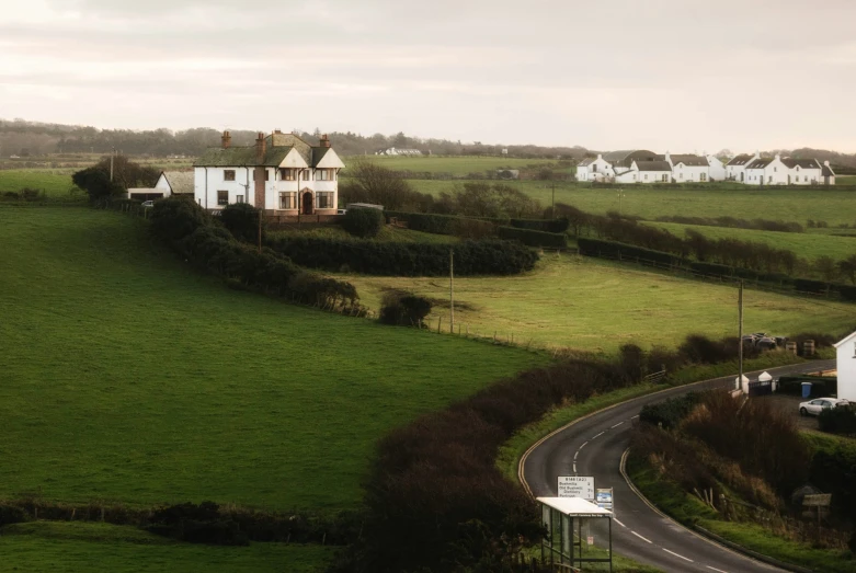 a green field with houses on the top of it