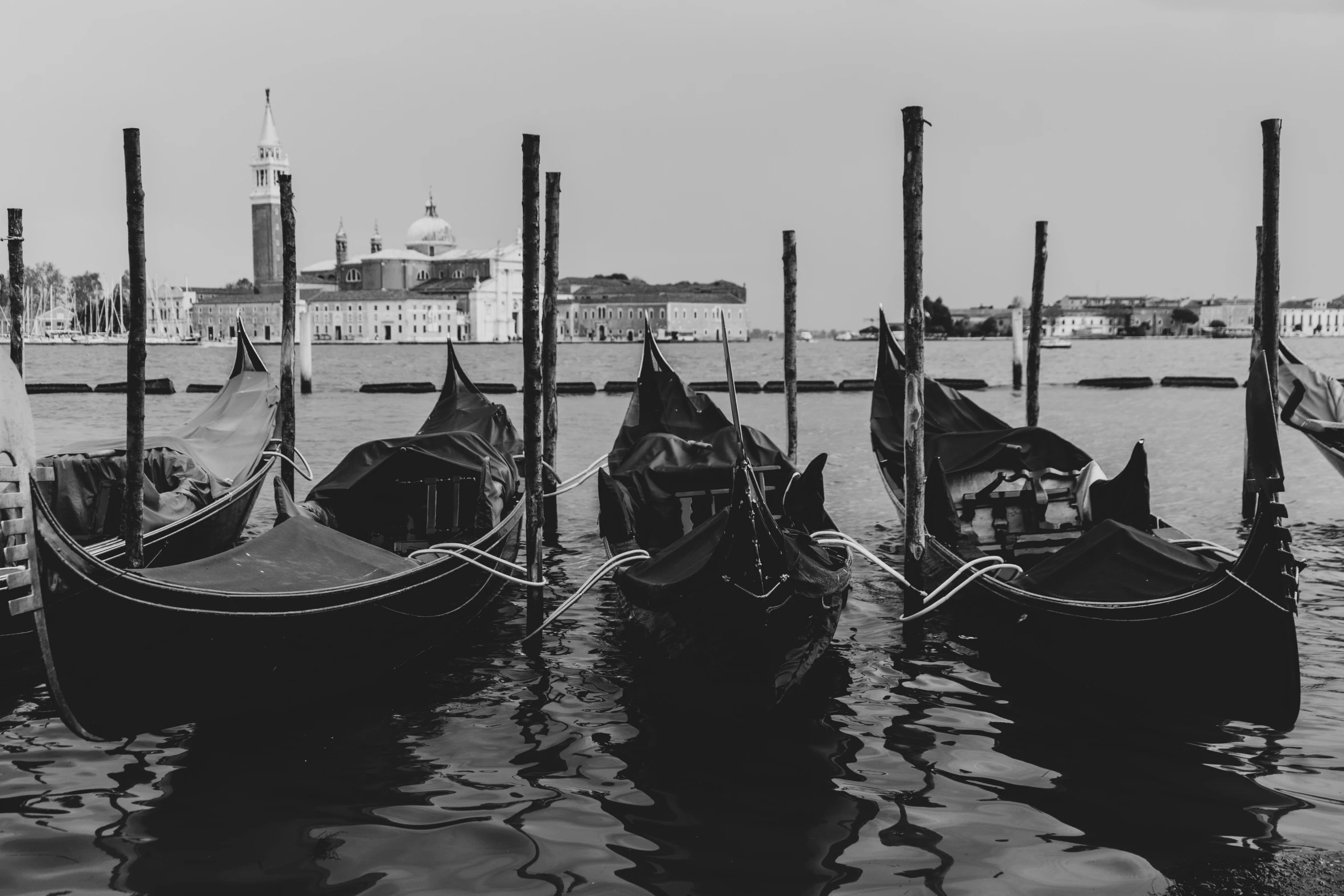 many gondolas docked next to each other on a river
