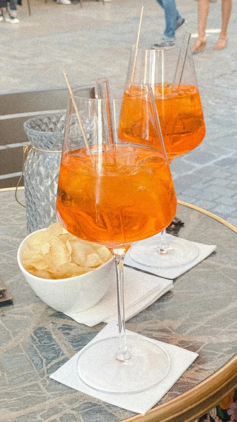 an array of drinks on a table with glasses