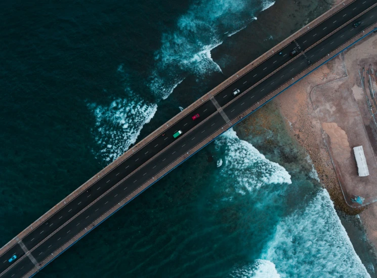 a bird's - eye view shows a long bridge over the ocean with vehicles