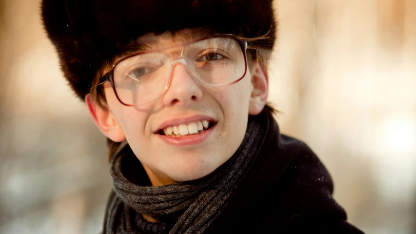 a young man wearing glasses and a hat