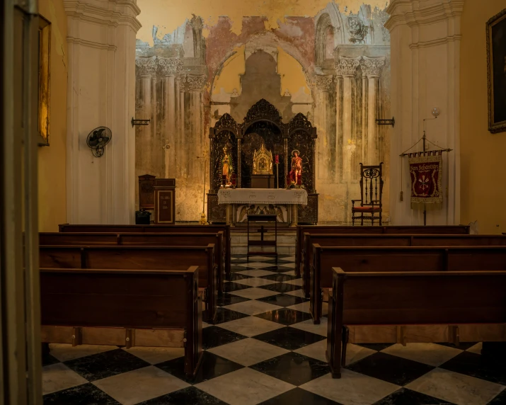 an open area in a church with two benches and a table