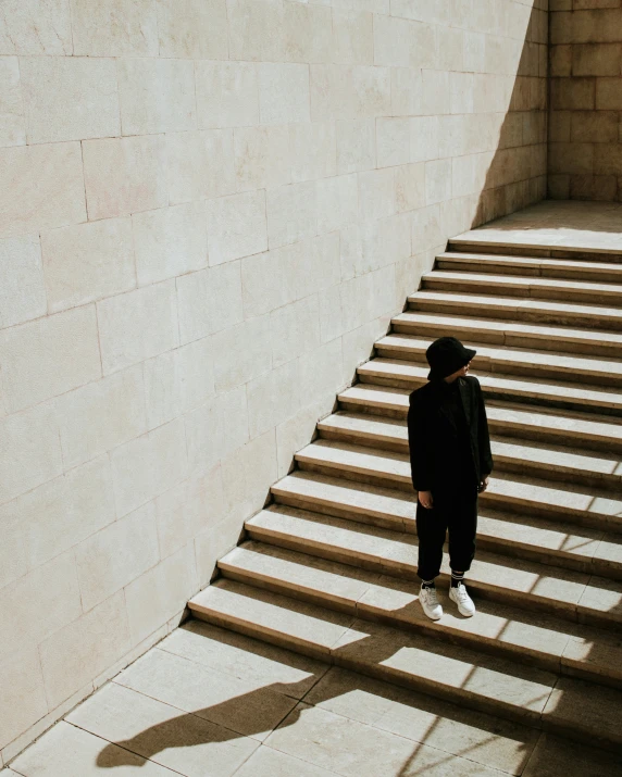 someone standing at a top of stairs by some walls