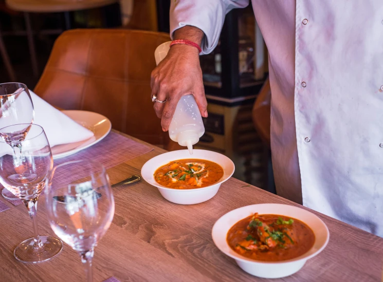 a man pouring his drink out to some food