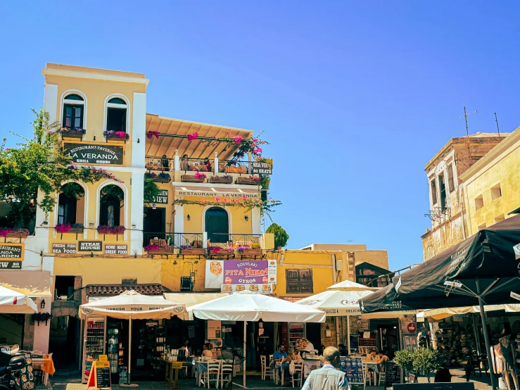 outdoor cafe in front of a yellow building with balconies