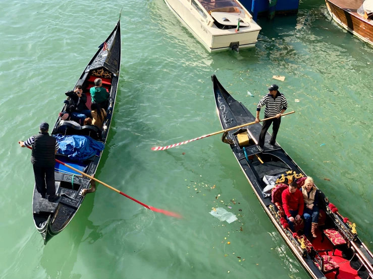 two long boats pulling up passengers on the water