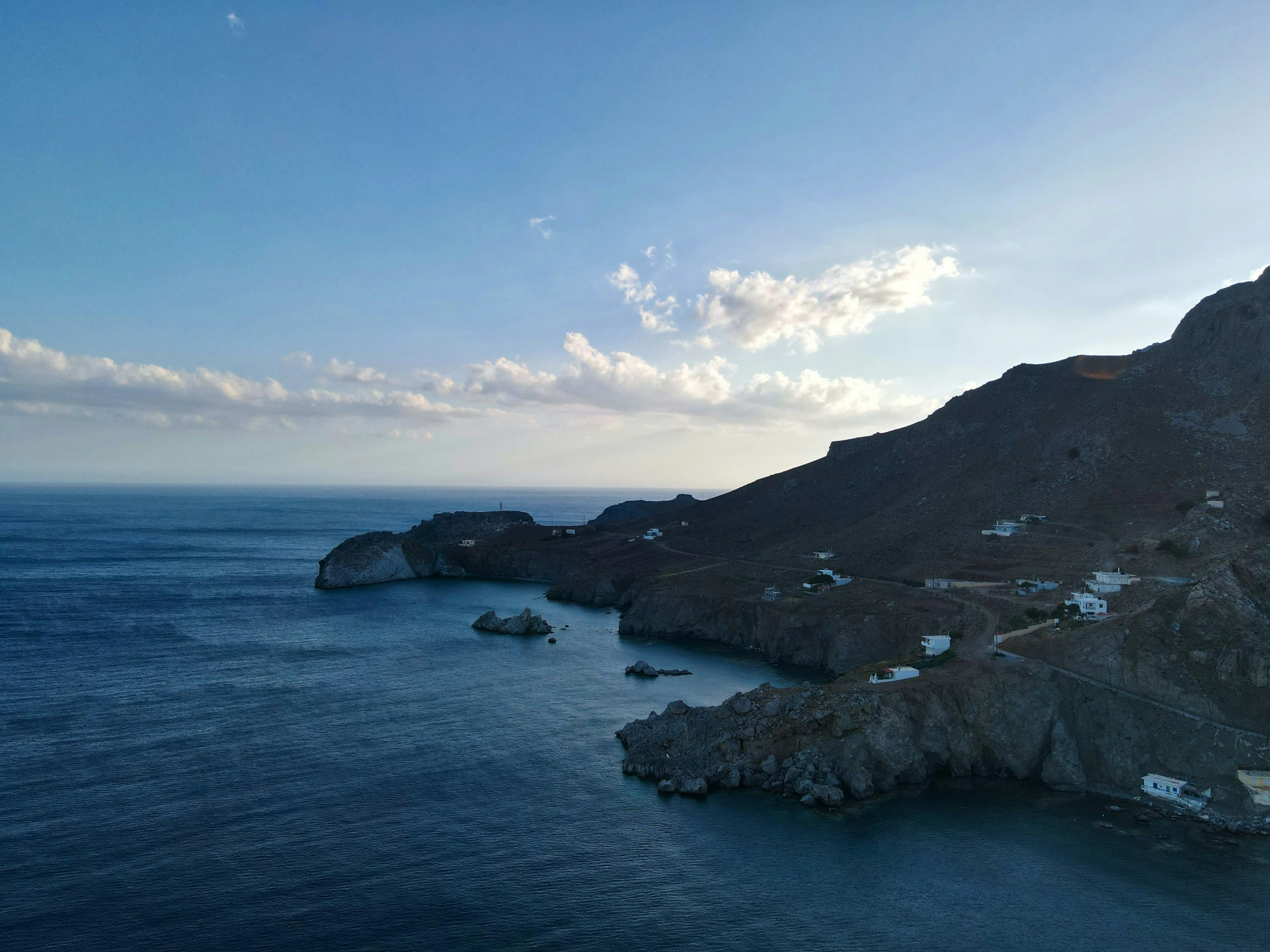 a body of water with many houses built into the mountain