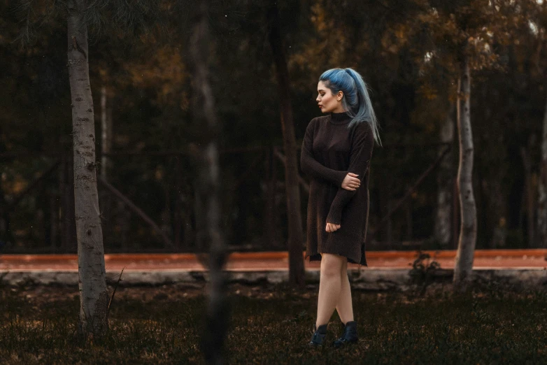 a woman wearing black and blue is standing outside