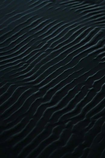 a close up of ripples in the water at night