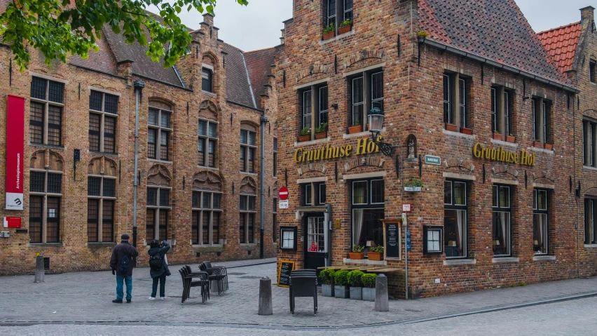 several people standing around a corner near an old building