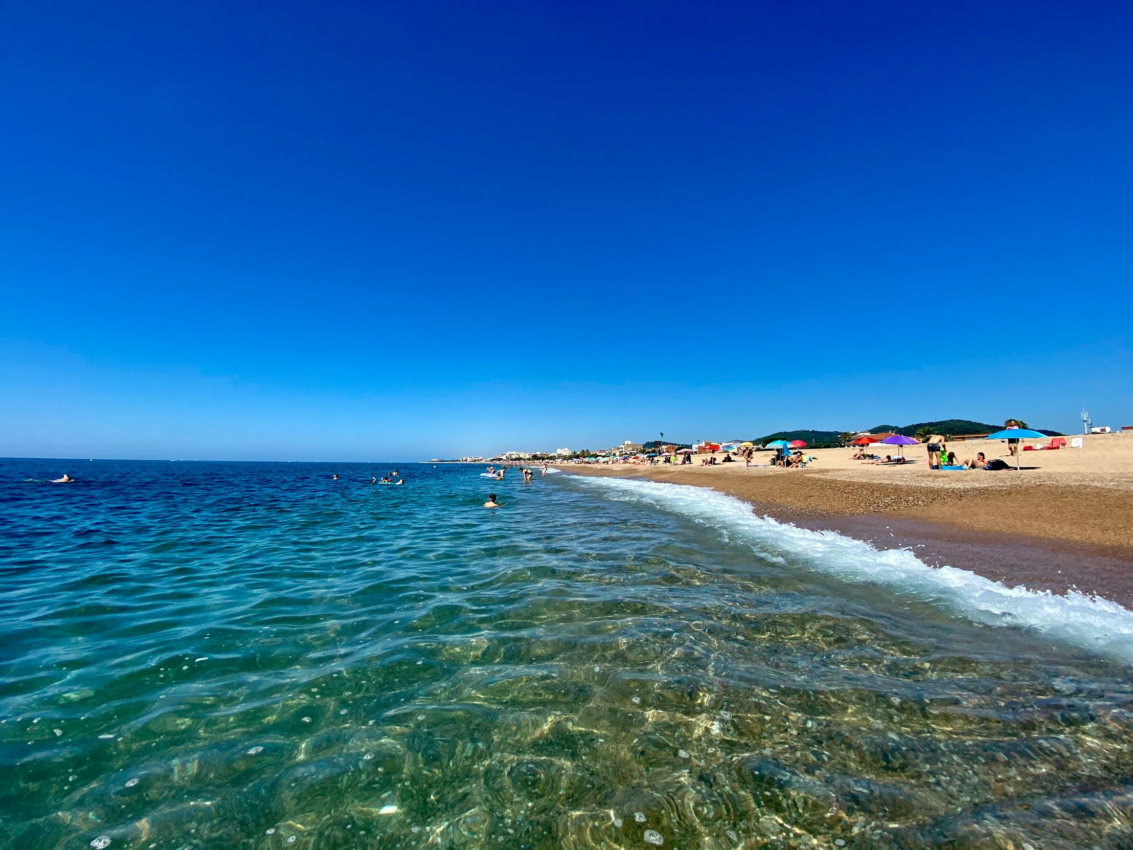 a view of people in bathing suits on the beach