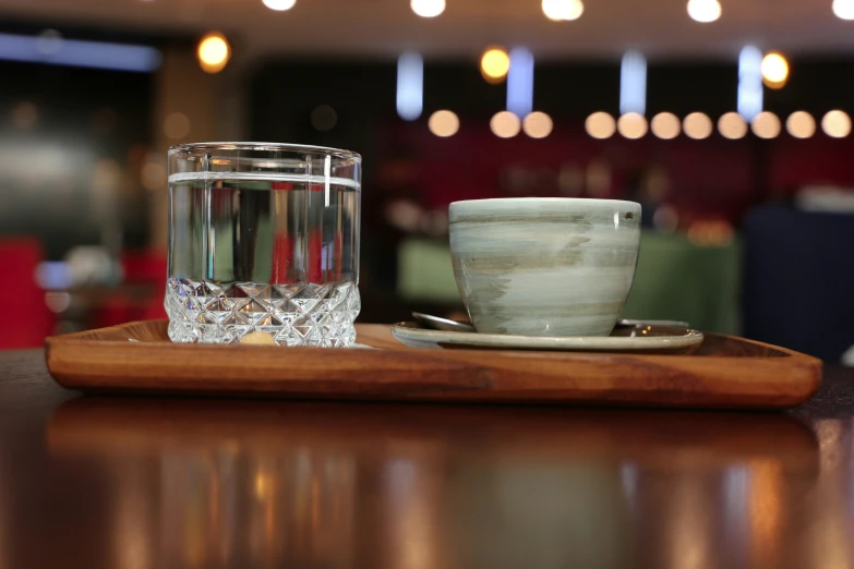 an empty glass and a teacup sit on a tray