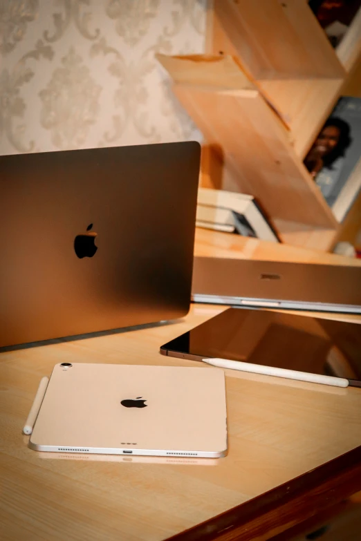 apple computer sitting on a desk with one open apple laptop