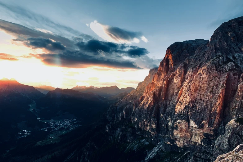 the sun is setting behind some mountain peaks