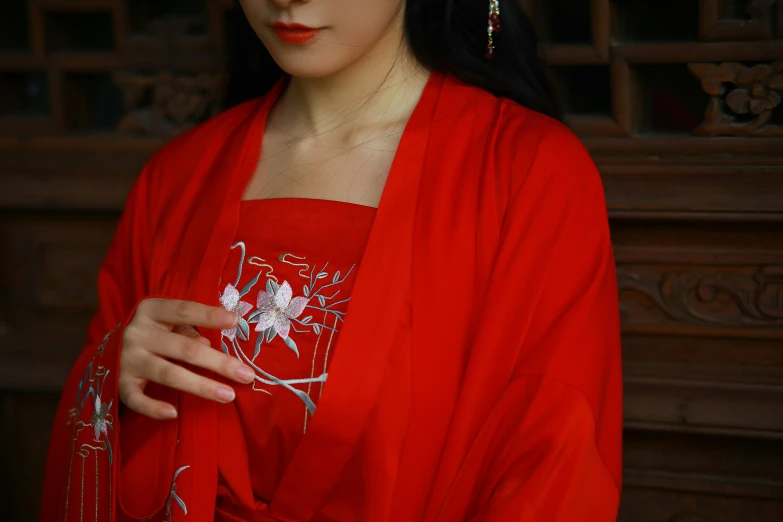 a girl in red dressed holding soing with both hands