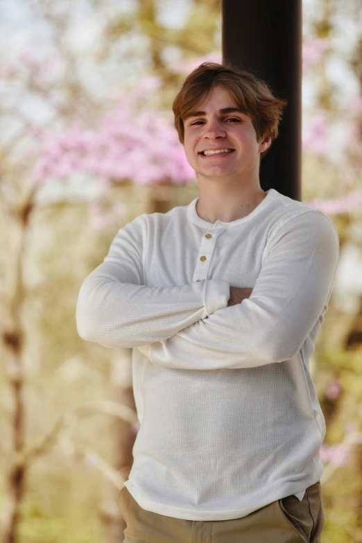 young man posing for a po near the top of tree