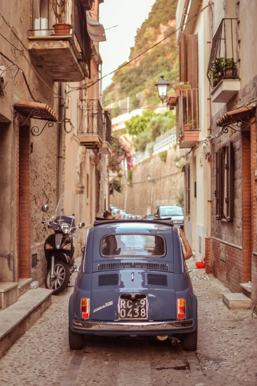 a vintage car parked along a street in a small town