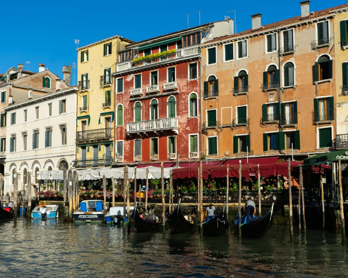 gondola boats are lined up near the buildings in venice