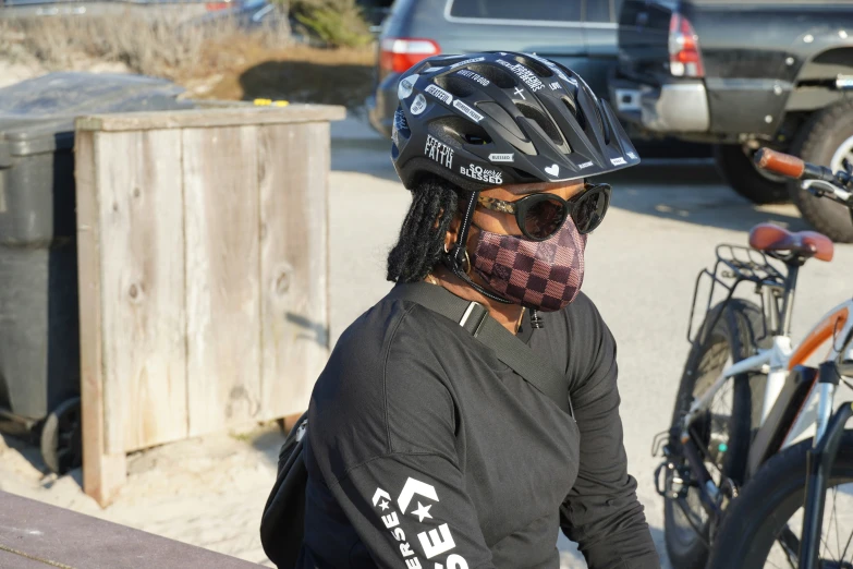 the person wearing a bandana stands next to their bike