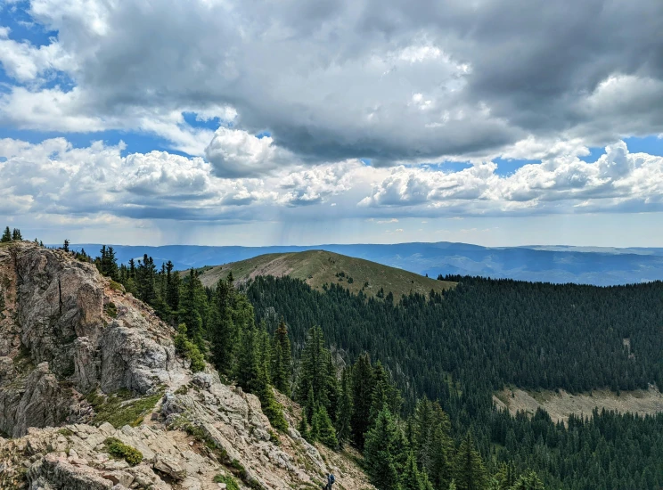 an expansive view of the mountains with a lone bench