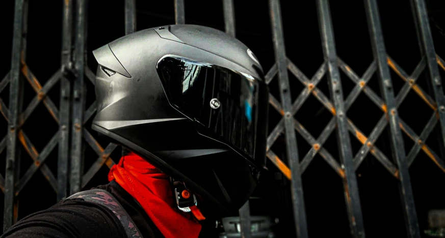 the helmet is next to the black metal fence