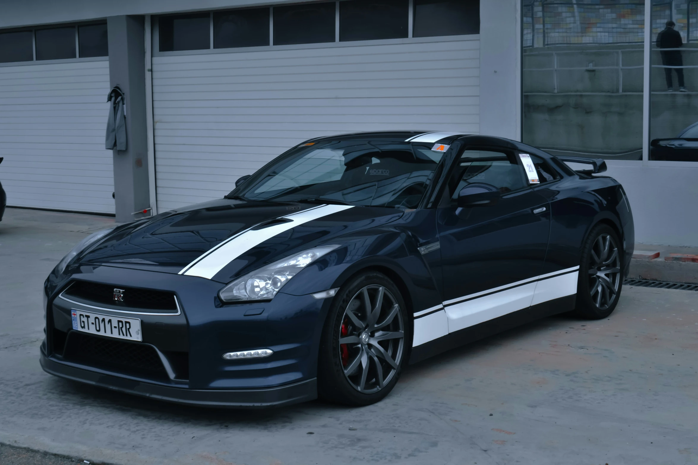 a black and white sports car parked next to a building