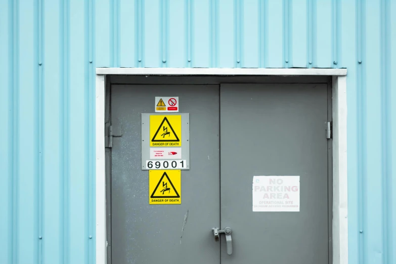 a door with signs on it in front of blue wall