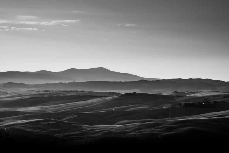 two hills and some trees with a sky background