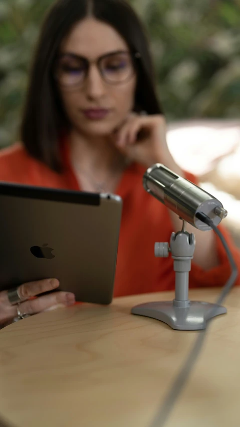 a person sitting at a table with an ipad in their hand