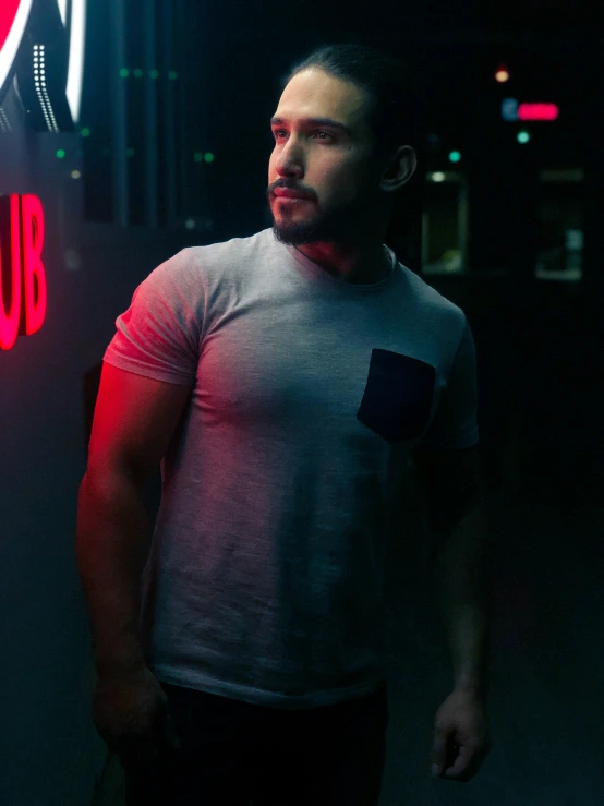 a man is standing in front of the neon sign