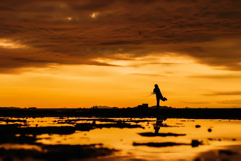 a person flying a kite in the sky during the sunset