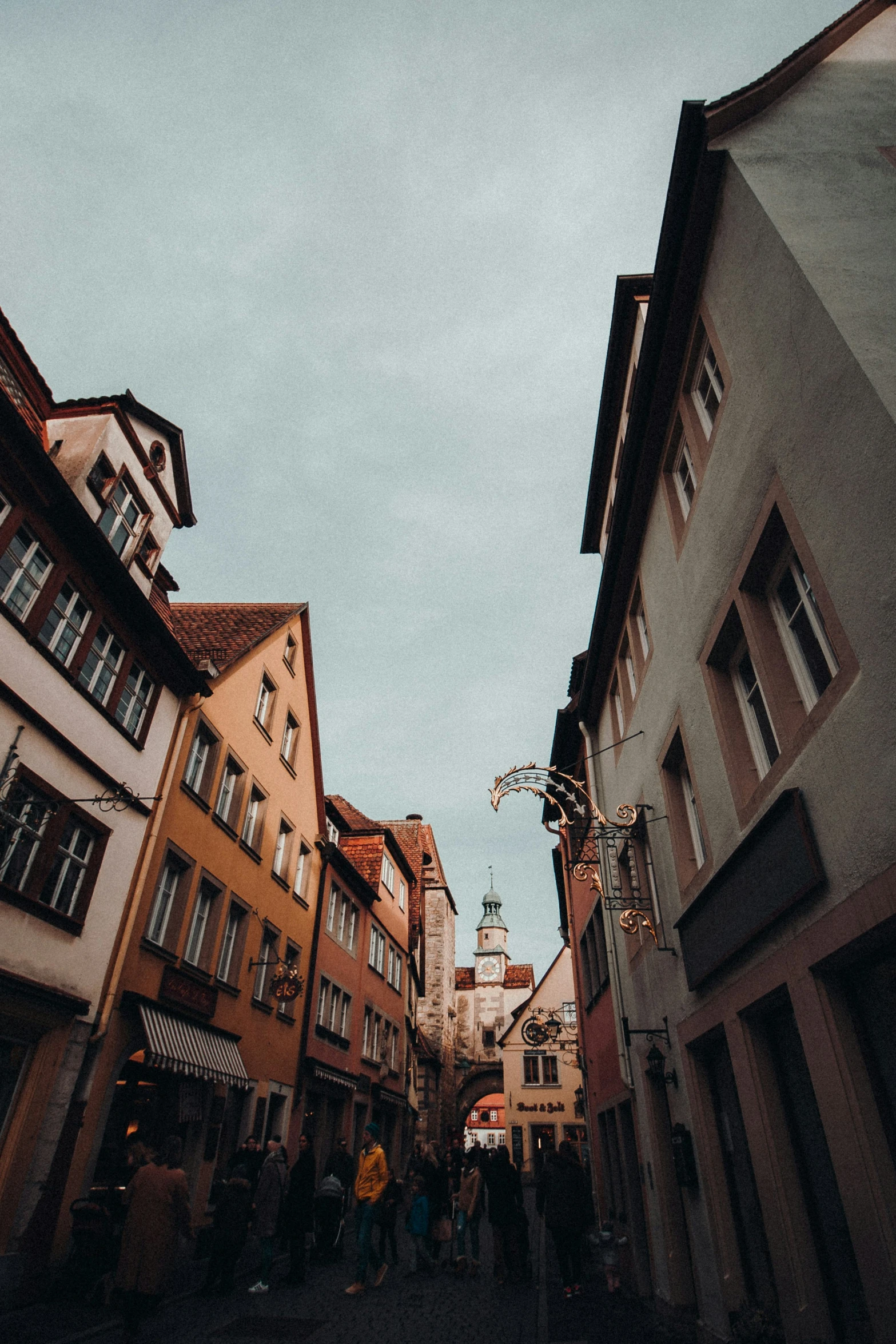 the back half of a narrow street with people in the middle