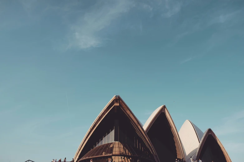 the view from a boat looking up at the building that has a large triangular shaped roof