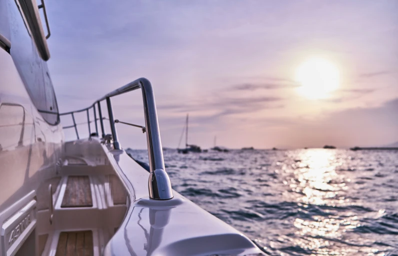 the view from the bow deck of a boat of sailboats out on the water