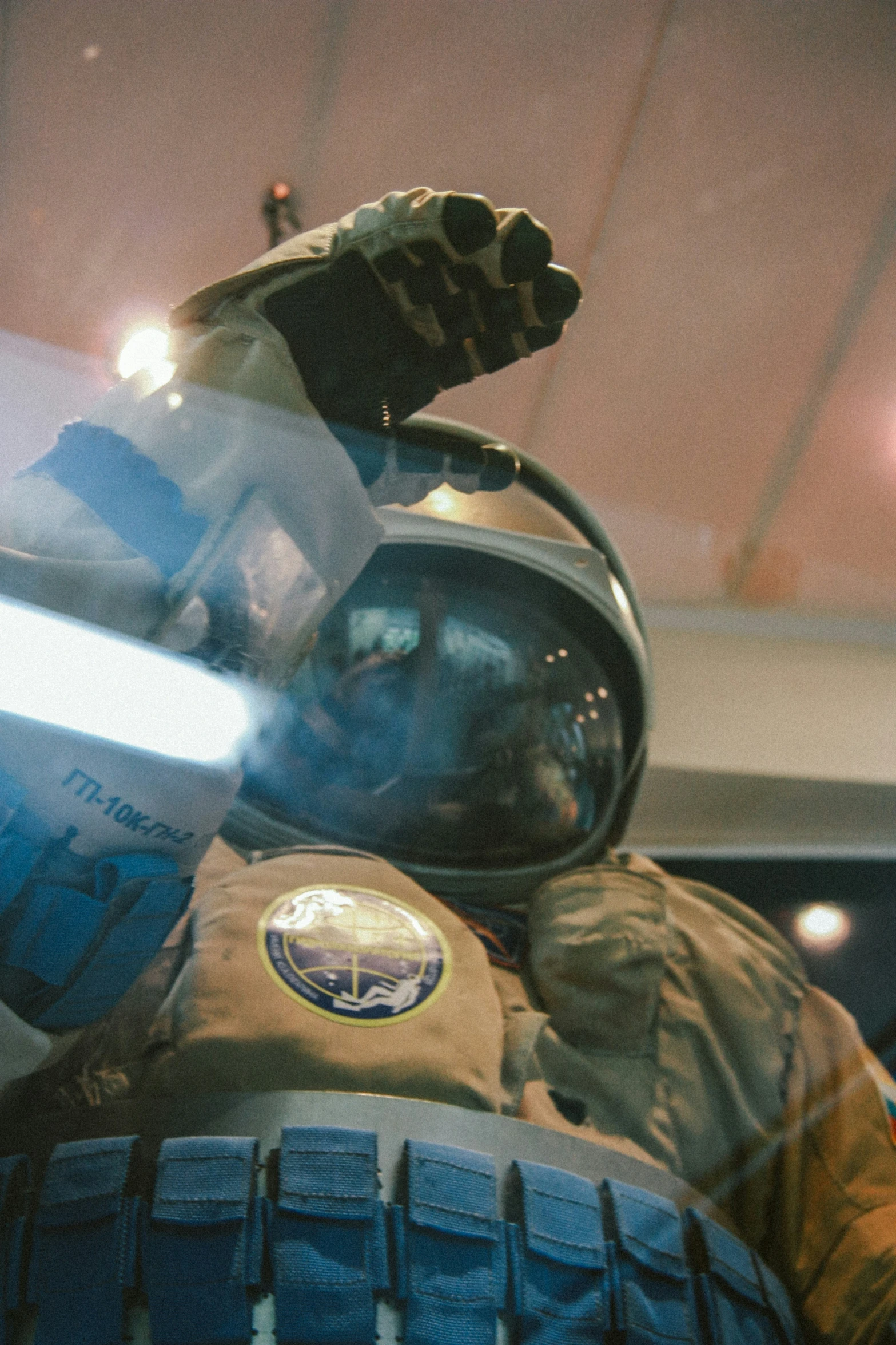 an astronaut's helmet with patches and a space shuttle on display