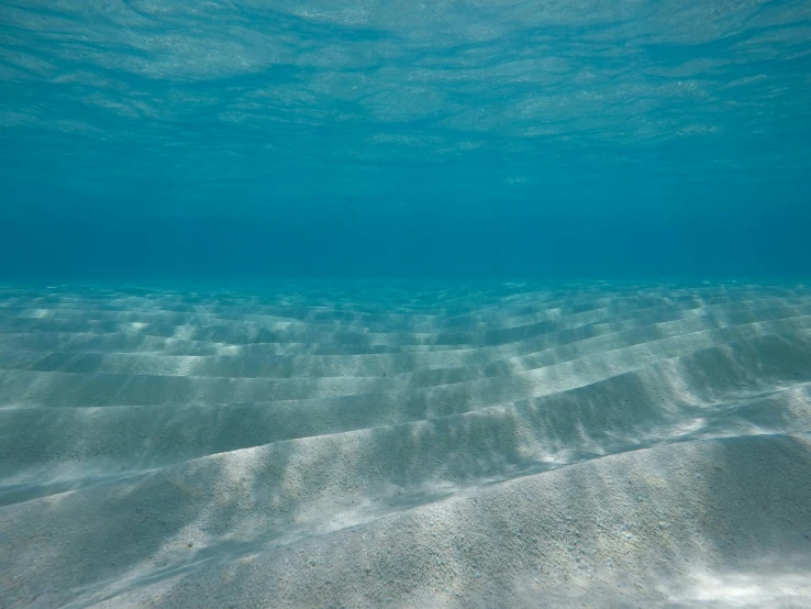 a clear ocean water with waves coming up the side