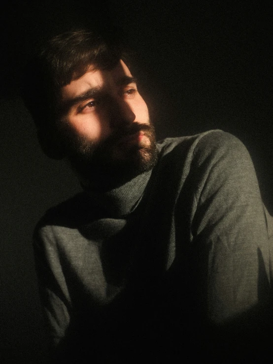 a man with a beard in a dark room