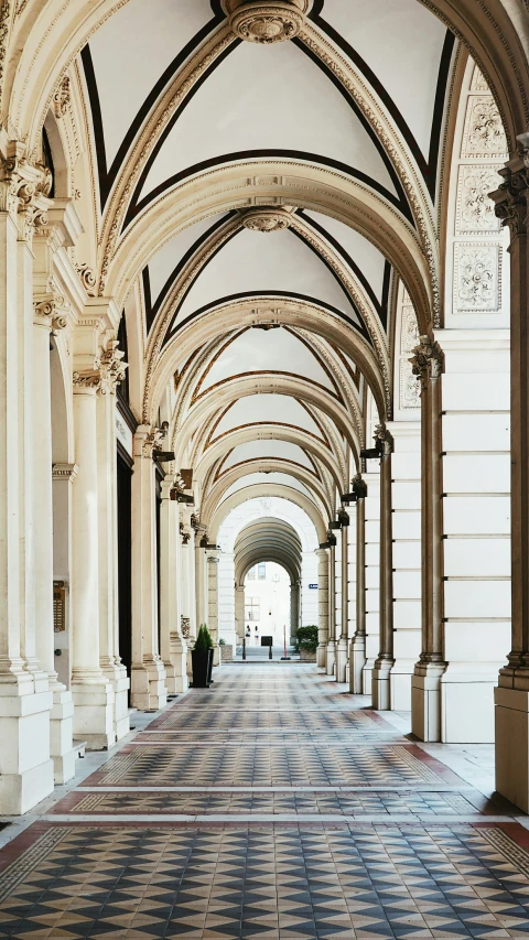 a hallway with tiled floors and high arches