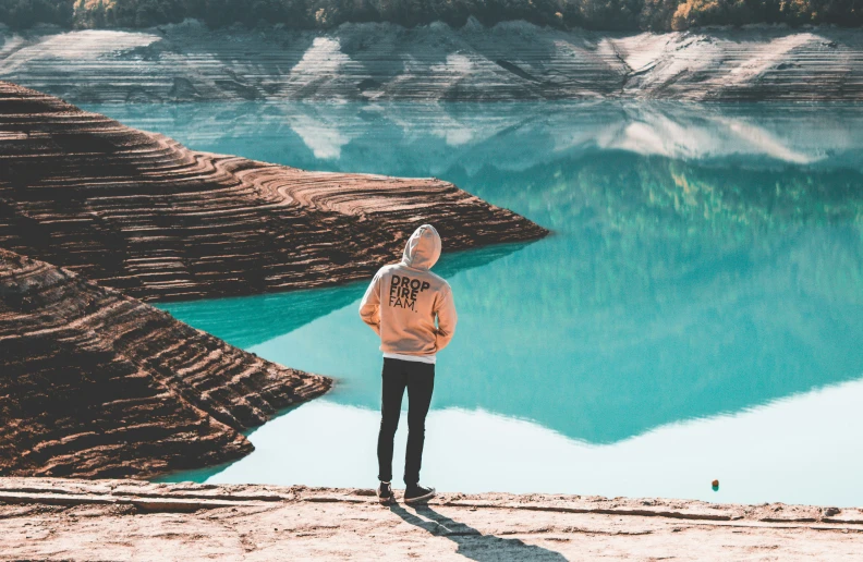 a person standing on the shore of a lake