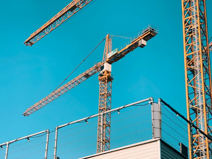 two construction cranes are standing next to each other