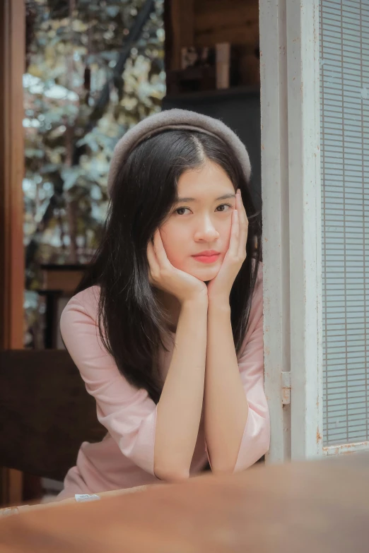 a girl with long hair sitting on the floor and looking away from camera