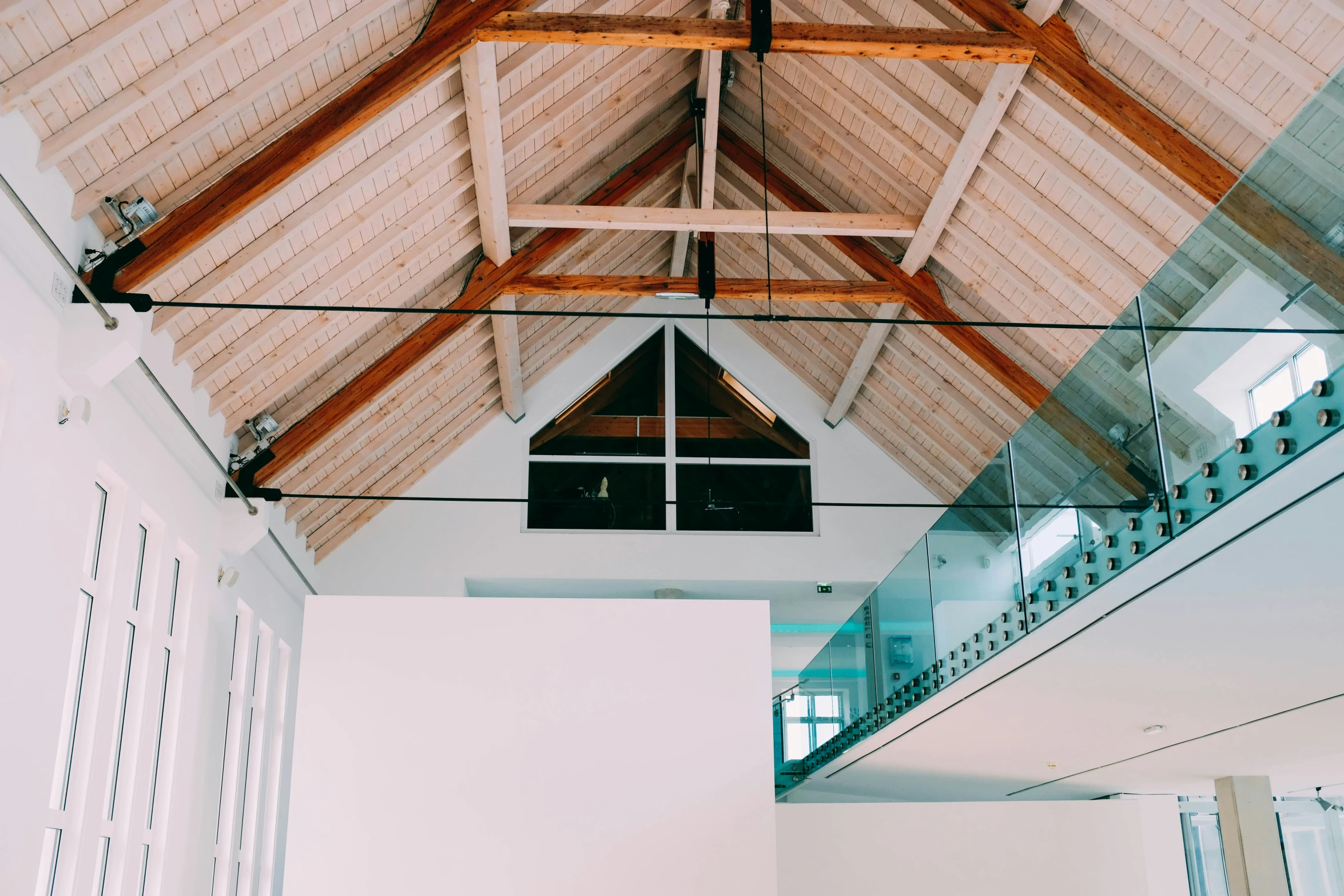 large open room with windows, wood framing and a roof