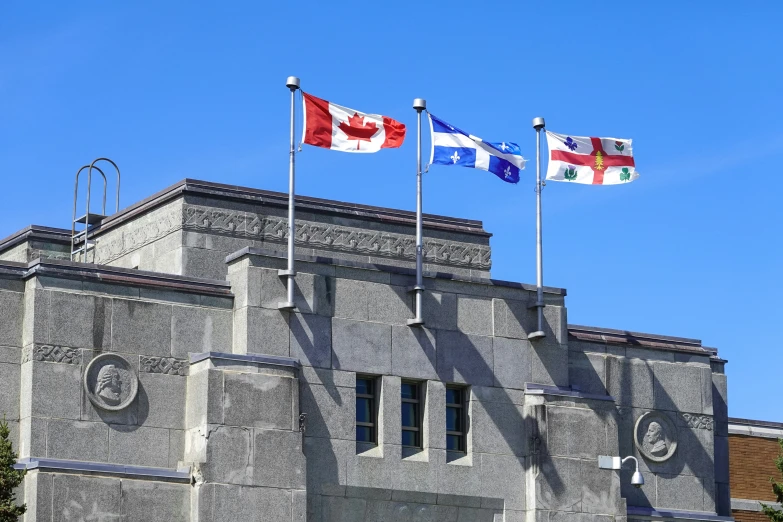 some very pretty flags on top of a big building