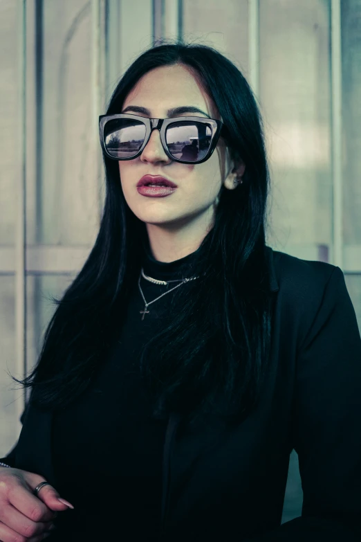 a woman wearing glasses with long black hair and a choket around her neck