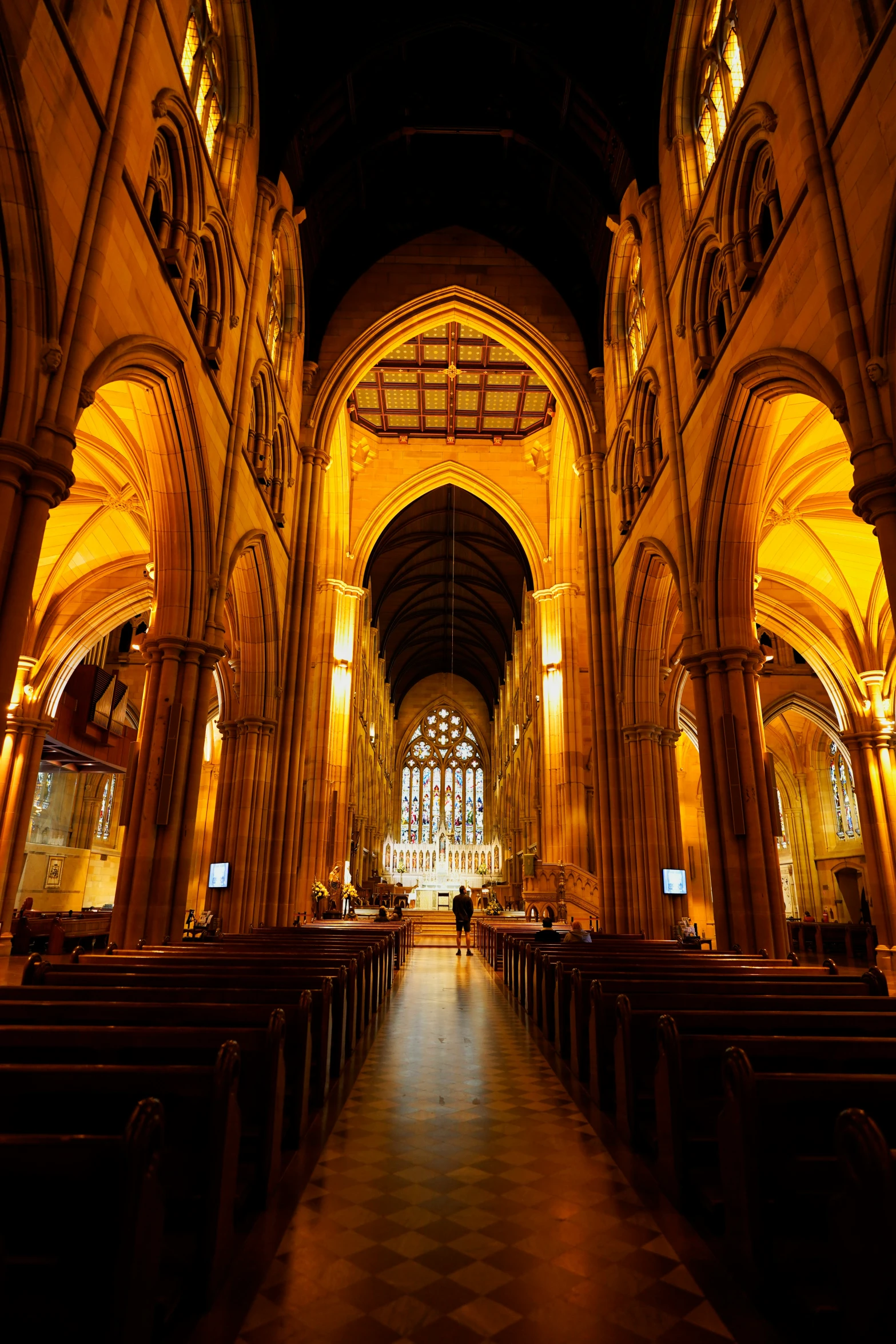 a long building with pews and several chandeliers