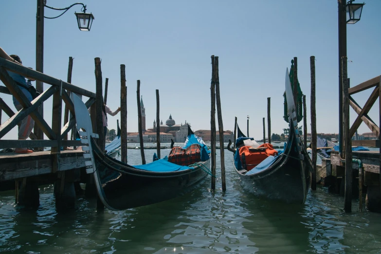 two gondolas with people in seats floating on the water