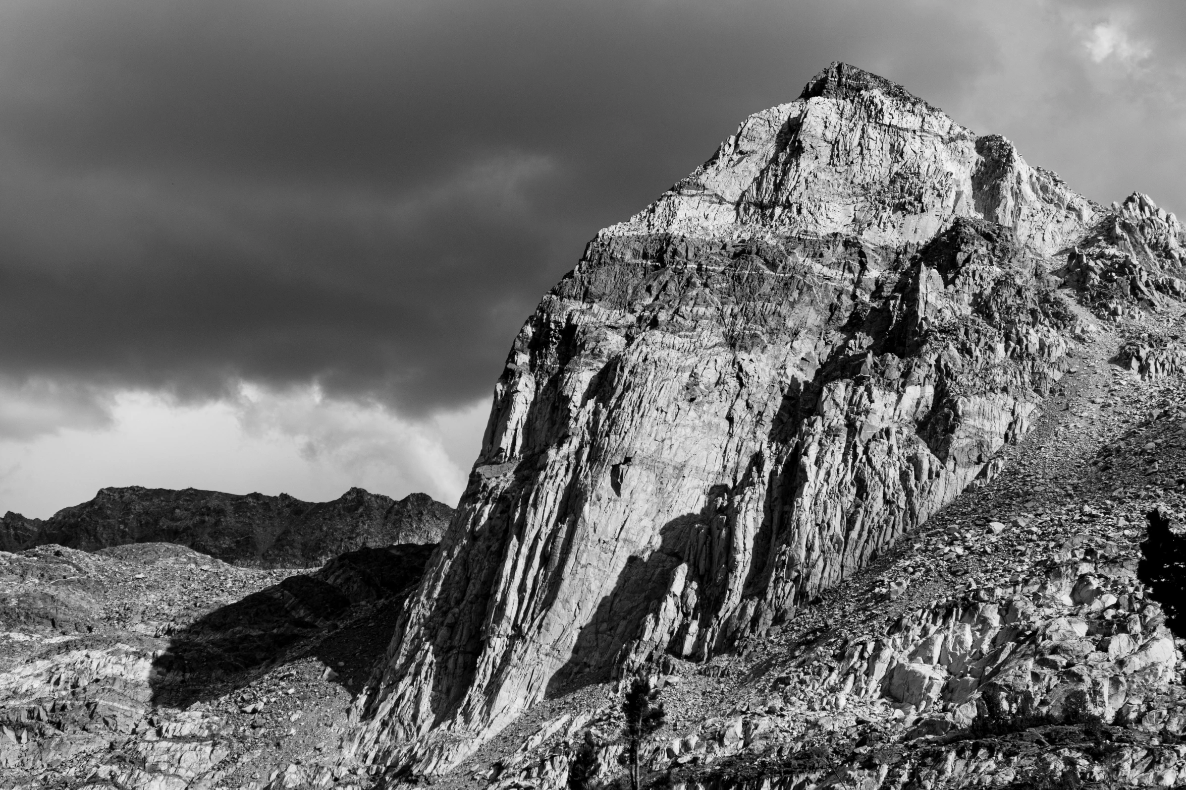 a rock face on the mountain under a cloudy sky