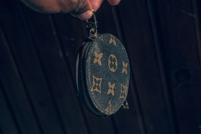 a man holding a small black round bag