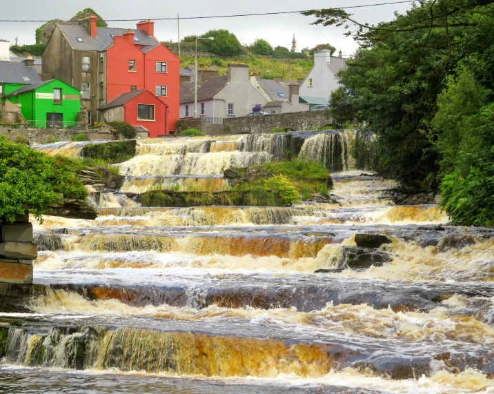 a small stream running between a village and a river bed