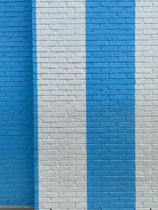 a couple of benches sitting in front of a blue and white wall